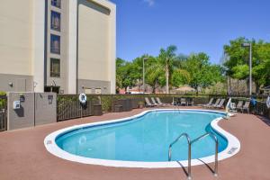 a swimming pool with chairs and a building at Hampton Inn Closest to Universal Orlando in Orlando