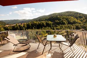 een tafel en stoelen op een balkon met een berg bij TOP VIEW APARTMENT in Sinaia