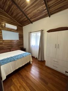 1 dormitorio con 1 cama, vestidor y ventana en Casa Cooper, en Carrillo