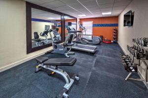 a gym with several tread machines and a mirror at Hampton Inn Orlando-Maingate South in Davenport