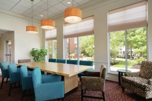 une salle à manger avec une table en bois et des chaises bleues dans l'établissement Hilton Garden Inn Harrisburg East, à Harrisburg