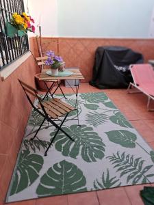 a table and a chair on a rug in a room at Casa Flamenca in Castilleja de la Cuesta