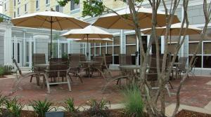 an outdoor patio with tables and chairs with umbrellas at Hilton Garden Inn Meridian in Meridian