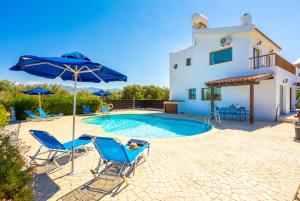 a villa with a swimming pool and two chairs and an umbrella at Blue Bay Villa Nicole in Mavroli