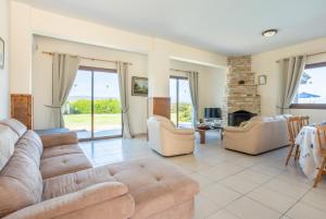 a living room with a couch and chairs and a fireplace at Blue Bay Villa Nicole in Mavroli