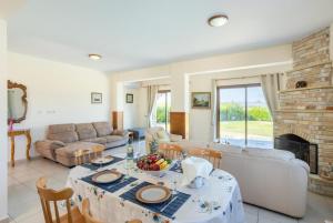 a living room with a table and a fireplace at Blue Bay Villa Nicole in Mavroli