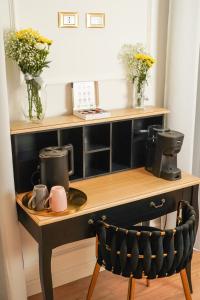 a desk with a coffee maker and flowers on it at Maison 31 - Suite accommodation in Santa Marinella
