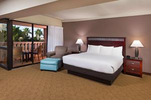 Habitación de hotel con cama, silla y escritorio. en Doubletree by Hilton Phoenix Mesa en Mesa