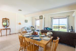 een woonkamer met een tafel en een bank bij Blue Bay Villa Thea in Mavroli