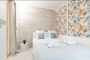 ニースにあるGrand appartement- Le Port A/Cのベッドルーム1室(ベッド2台付)が備わります。壁には絵画が飾られています。