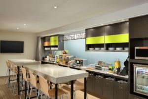 a kitchen with a counter with tables and chairs at Home2 Suites By Hilton McAllen in McAllen