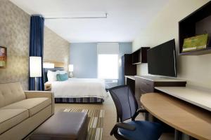 um grande quarto de hotel com uma cama e uma secretária em Home2 Suites By Hilton McAllen em McAllen