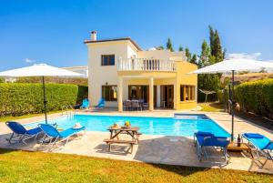 a villa with a swimming pool and a house at Villa Tsikkos Tessera in Argaka