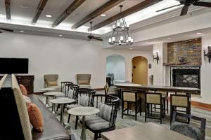 a dining room with tables and chairs and a fireplace at Homewood Suites by Hilton McAllen in McAllen