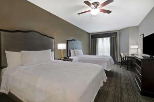 a hotel room with two beds and a flat screen tv at Homewood Suites by Hilton McAllen in McAllen