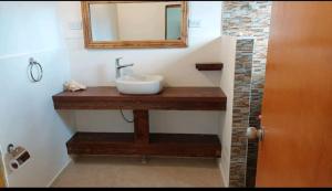 ein Bad mit einem Waschbecken und einem Spiegel in der Unterkunft Frenchy's in Providencia