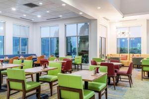 a restaurant with tables and chairs and windows at Hilton Garden Inn Morgantown in Morgantown