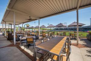 a patio with wooden tables and chairs and umbrellas at Hilton Garden Inn Manchester Downtown in Manchester