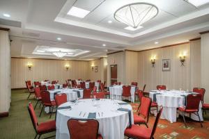 a banquet room with white tables and red chairs at Hilton Garden Inn Morgantown in Morgantown