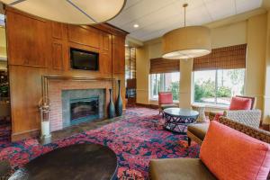 a living room with a fireplace and a tv at Hilton Garden Inn Manchester Downtown in Manchester