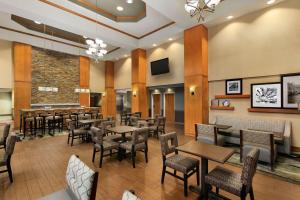 a restaurant with tables and chairs and a bar at Hampton Inn & Suites by Hilton Manchester Bedford in Bedford