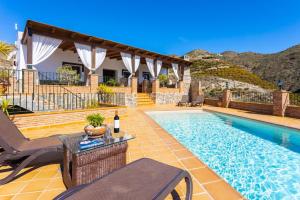 a villa with a swimming pool and a house at Villa Flores in Almuñécar