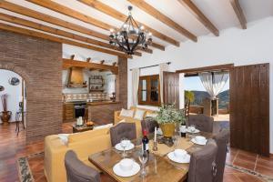 a dining room and living room with a table and chairs at Villa Flores in Almuñécar