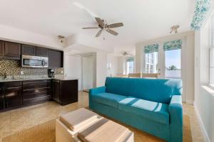 a living room with a blue couch and a kitchen at Hilton Vacation Club Crescent on South Beach Miami in Miami Beach