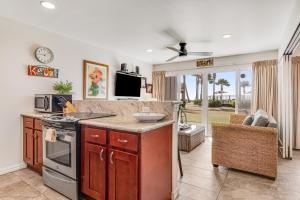 a kitchen with a counter with a stove and a tv at Kauai Kailani Resort #109 in Kapaa