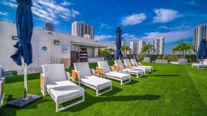 une rangée de chaises sur une pelouse avec des parasols bleus dans l'établissement Hilton Miami Downtown, à Miami