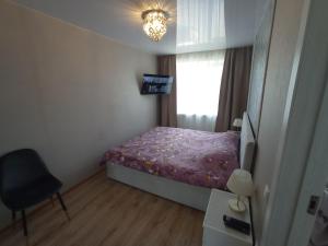 ein kleines Schlafzimmer mit einem Bett und einem Fenster in der Unterkunft New Energia apartment in center city in Narva