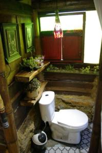 a bathroom with a toilet and a window at Aldea Victoria. in Santa Elena