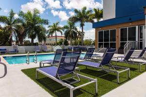 a group of lounge chairs next to a swimming pool at Hampton Inn & Suites Miami Airport South/Blue Lagoon in Miami