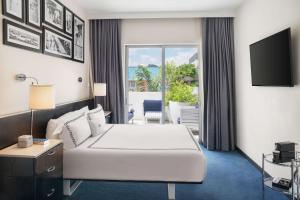 a hotel room with a bed and a television at Gale South Beach, Curio Collection By Hilton in Miami Beach