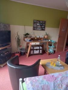 a living room with a table and a tv at Hübsches Zimmer nahe BER in Berlin