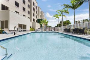 a swimming pool at a hotel with palm trees at Hampton Inn & Suites Miami, Kendall, Executive Airport in Kendall