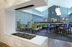 a restaurant with a fireplace in the middle of a room at Homewood Suites by Hilton Miami - Airport West in Miami