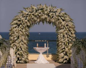 an arch with white flowers and candles on a table at DoubleTree by Hilton Ocean Point Resort - North Miami Beach in Miami Beach