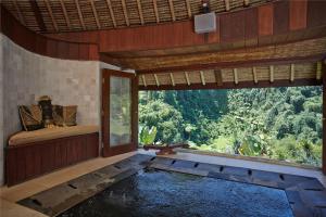 a room with a swimming pool and a large window at Bagus Jati Health & Wellbeing Retreat in Tegalalang
