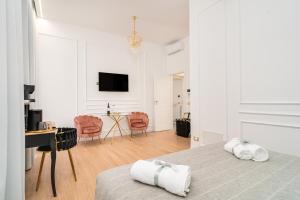 a white bedroom with a bed and a desk at Maison 31 - Suite accommodation in Santa Marinella