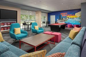 Tru By Hilton Miami West Brickell في ميامي: غرفة معيشة مع أريكة وطاولة تنس طاولة