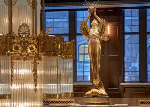 a gold statue of a goddess in a room with windows at Hotel Phillips Kansas City, Curio Collection By Hilton in Kansas City