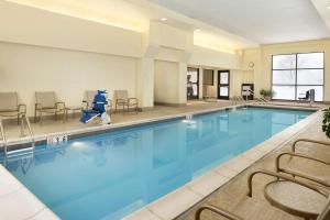 una piscina con sillas y sillas alrededor en DoubleTree by Hilton Milwaukee/Brookfield, en Brookfield