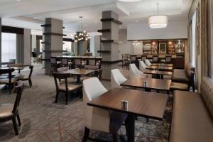 ein Restaurant mit Tischen und Stühlen und eine Bar in der Unterkunft DoubleTree by Hilton Milwaukee/Brookfield in Brookfield