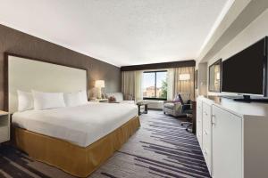 a hotel room with a bed and a flat screen tv at DoubleTree by Hilton Milwaukee/Brookfield in Brookfield