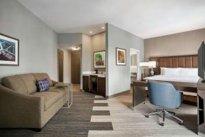 um quarto de hotel com uma cama, uma secretária e um sofá em Hampton Inn Suites Kansas City Downtown Crossroads em Kansas City
