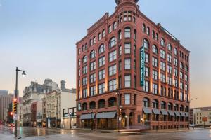 a large red brick building on a city street at Homewood Suites By Hilton Milwaukee Downtown in Milwaukee