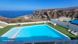 a large swimming pool with a view of the ocean at Puerto Rico Top Teide and Amadores View in Puerto Rico de Gran Canaria