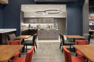 um restaurante com mesas e cadeiras de madeira e uma cozinha em Homewood Suites By Hilton Milwaukee Downtown em Milwaukee