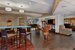 a lobby with a bar and chairs and a kitchen at Hampton Inn Milwaukee Northwest in Milwaukee